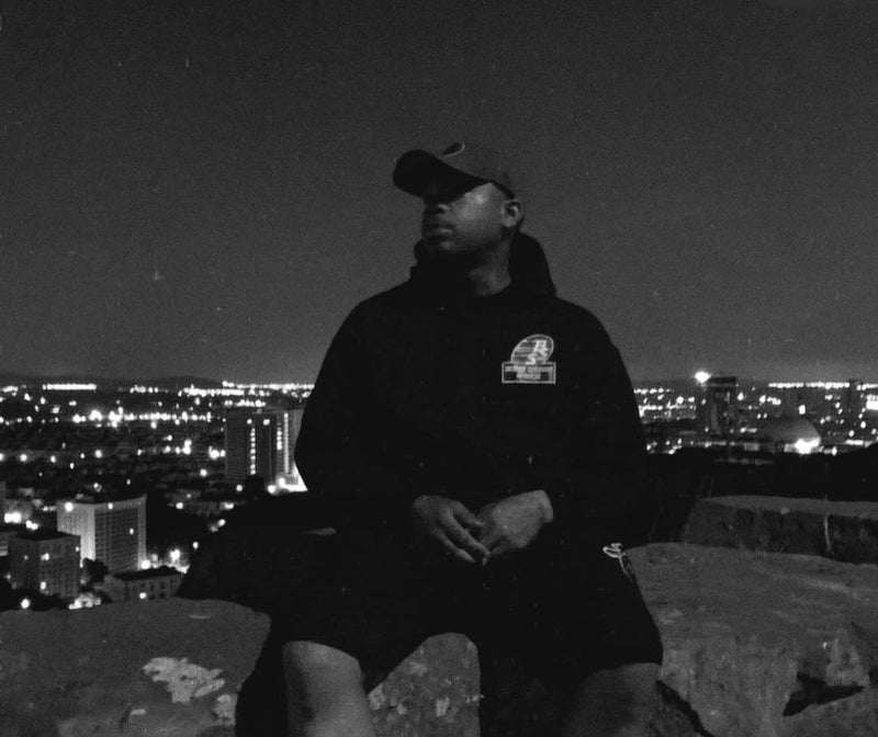 1Hunnit-K (@1hunnitkofficial on Instagram) wearing our black B.S.S. "White/Black Logo" Hoodie while traveling the road! Get yours now and rep